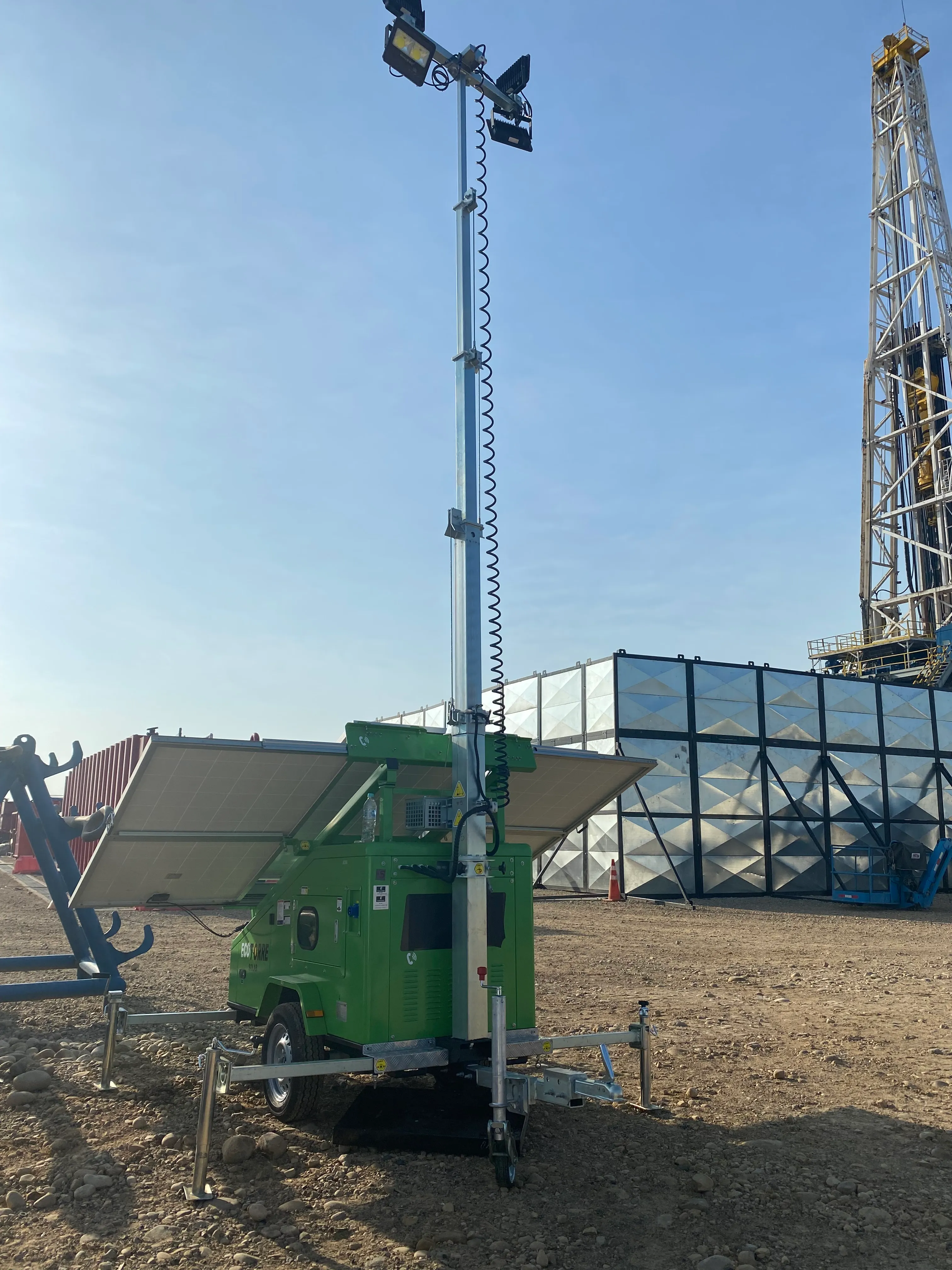 Torre de iluminación portátil en funcionamiento al atardecer, brindando luz sostenible en el área de trabajo